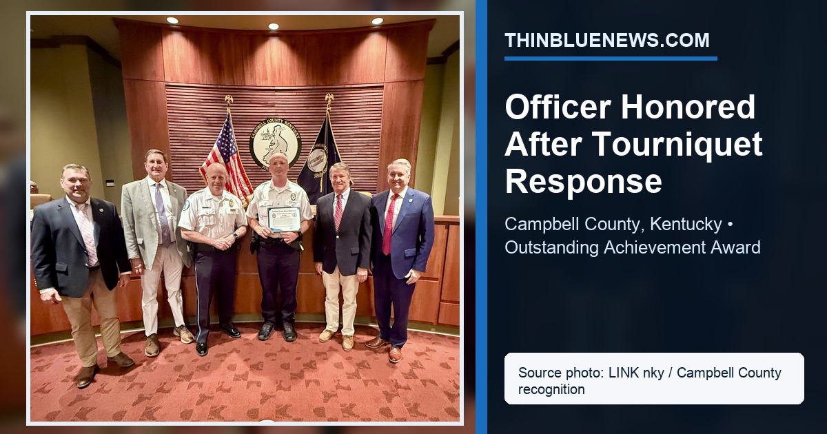 LINK nky source photo showing Campbell County Police Officer Samuel Broomall holding an Outstanding Achievement Award certificate during a Campbell County fiscal court meeting; ThinBlueNews added headline/source labeling.