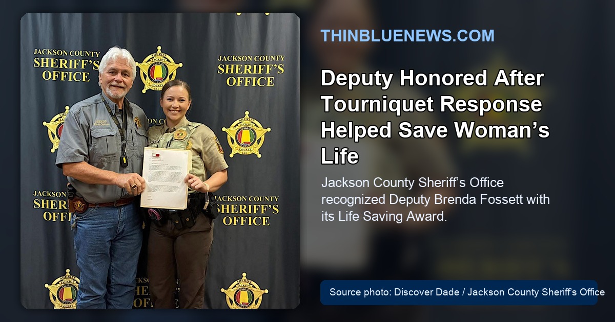 Discover Dade source photo showing Jackson County Deputy Brenda Fossett holding a Life Saving Award letter in front of a Jackson County Sheriff’s Office backdrop, with ThinBlueNews headline and source labeling added.