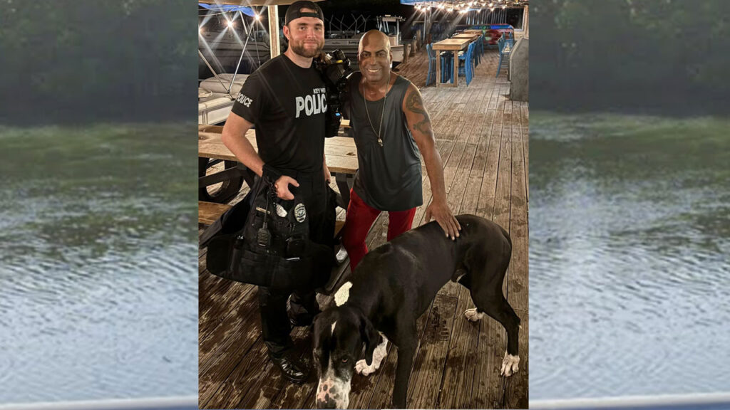 Key West Police Officer Corey Vanderhoof with rescued man and Great Dane after Hurricane Hole lagoon rescue, source photo via Local 10 News