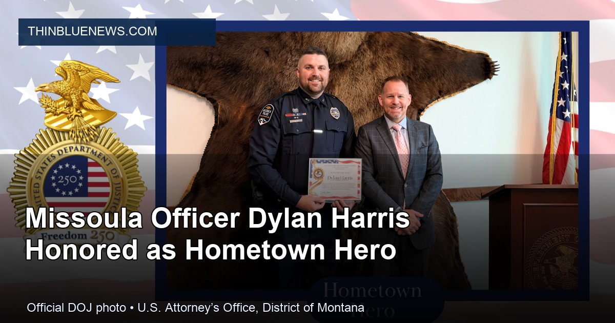 Official U.S. Attorney’s Office, District of Montana photo showing Acting U.S. Attorney Tim Racicot presenting Missoula Police Officer Dylan Harris with a Hometown Hero Award; ThinBlueNews added headline and source labeling.