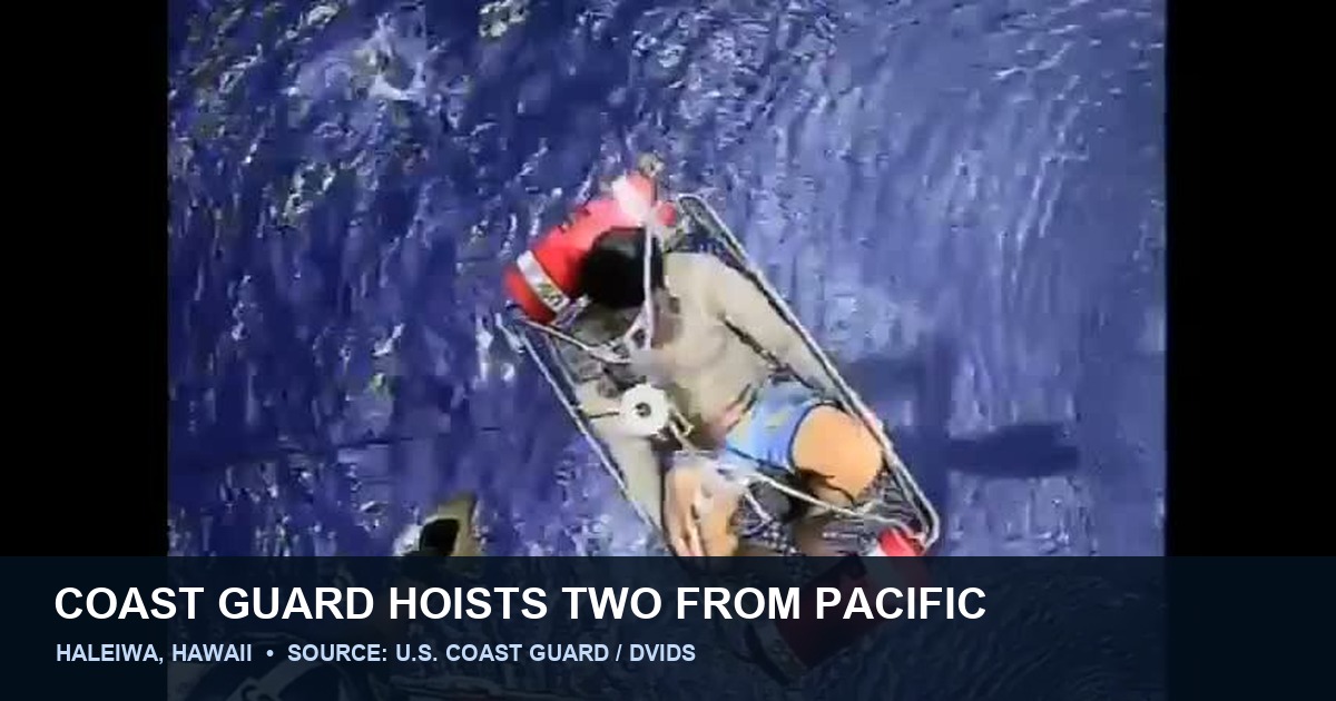 Official U.S. Coast Guard video frame showing a rescue basket and survivor below an MH-65 Dolphin during the July 14, 2026 rescue off Haleiwa, Hawaii.