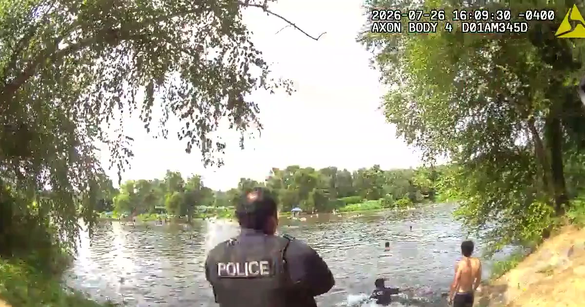Fredericksburg police body-camera frame showing officers moving into the Rappahannock River to reach a swimmer on July 26, 2026.