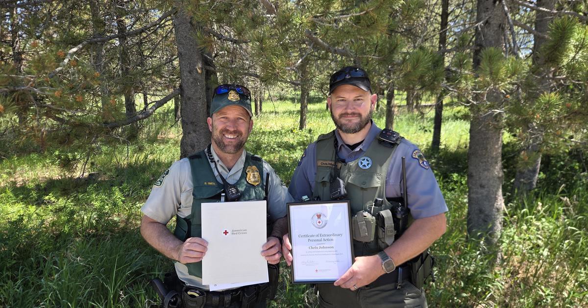 U.S. Forest Service Officer Branden Smith and Idaho Fish and Game Conservation Officer Chris Johnson holding American Red Cross lifesaving awards
