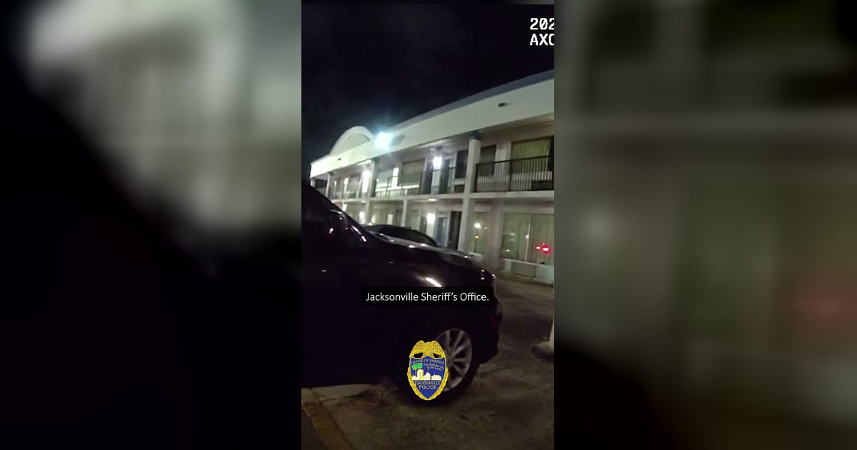 True Jacksonville Sheriff's Office body-camera frame showing the motel exterior during a multi-agency rescue operation