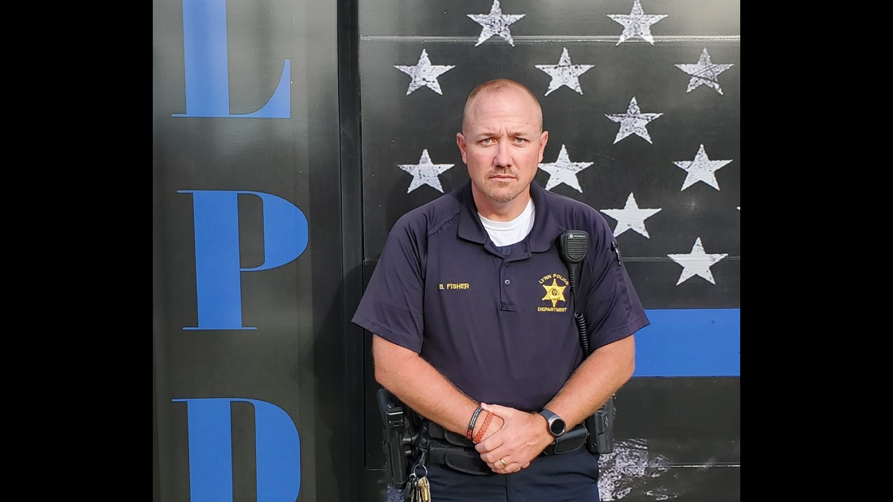 Lynn Town Marshal Brad Fisher in uniform in front of a Lynn Police Department backdrop