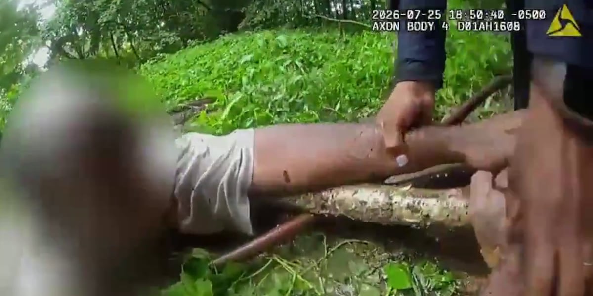 Memphis Police Department body-camera frame showing officers using branches to pull a man from Cypress Creek after floodwater swept him downstream