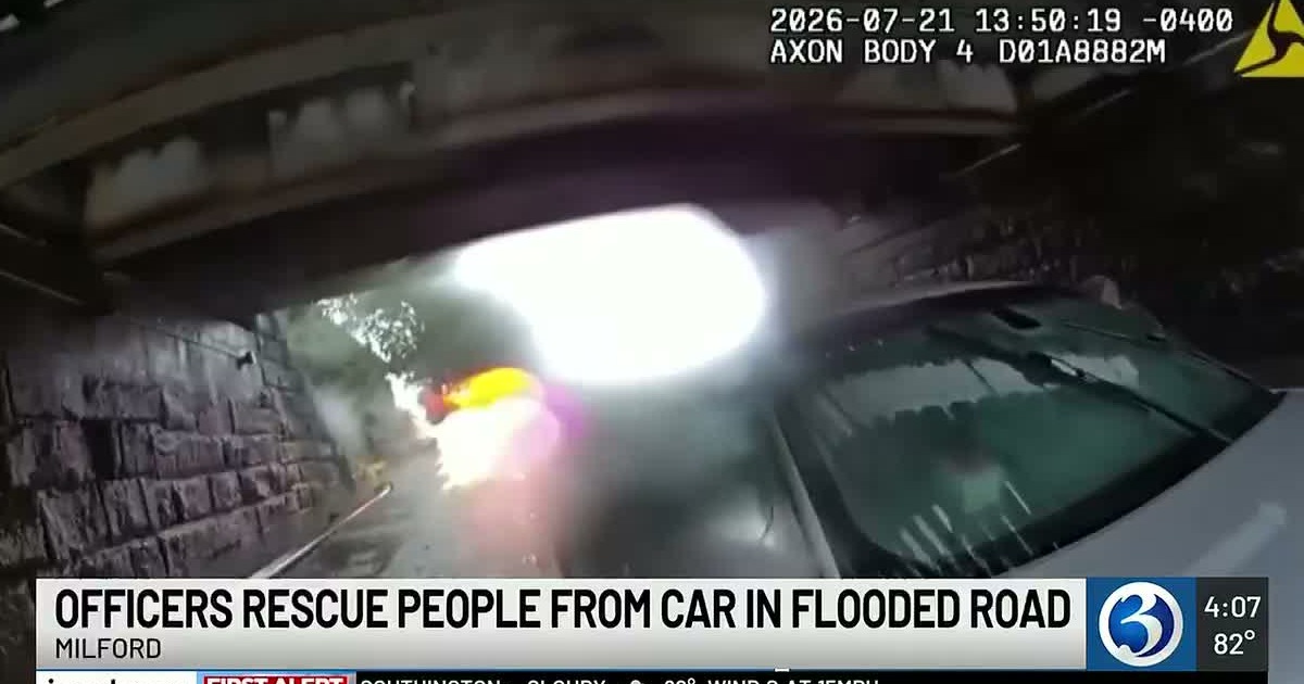 Milford Police Department body-camera frame showing a flooded car beneath an overpass after officers rescued two occupants on July 21, 2026.