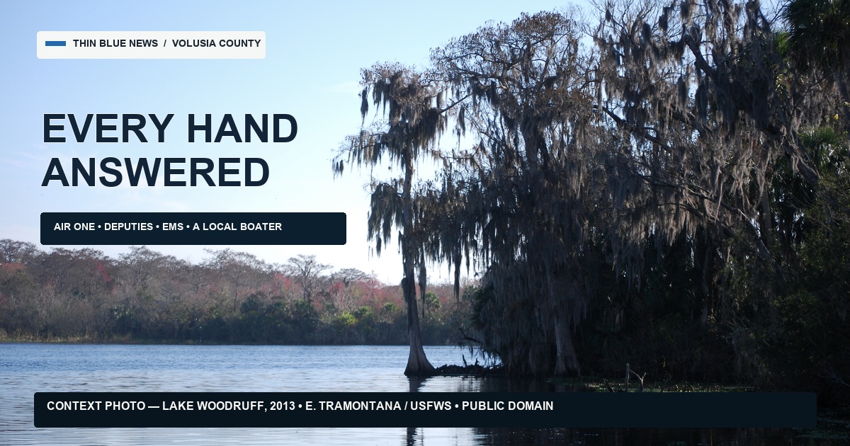 Context photograph of Lake Woodruff with cypress trees and reflections, carrying the words Every Hand Answered; the image is labeled as a 2013 USFWS public-domain context photo.