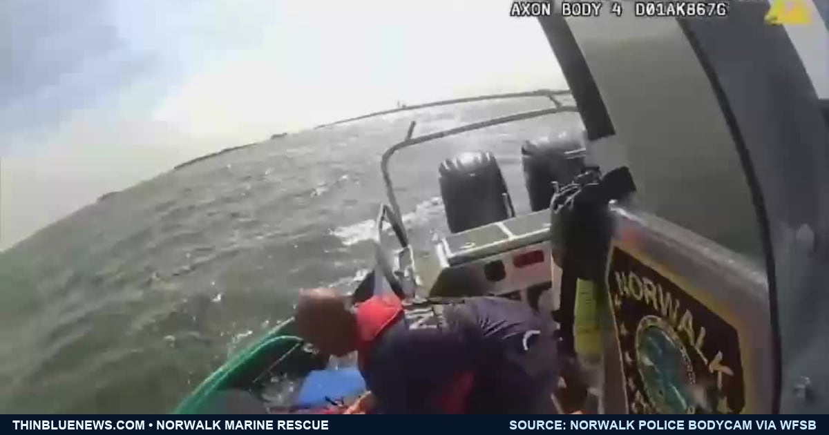 Genuine Norwalk Police Department body-camera frame, published by WFSB, showing officers bringing a face-blurred kayaker aboard a Marine Unit vessel beside a green kayak in Long Island Sound.