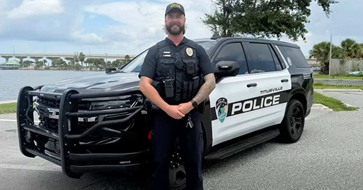 Titusville Police Officer Van Zile standing in uniform in front of a marked Titusville Police cruiser.