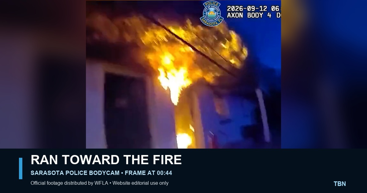 Official Sarasota Police Department body-camera frame showing flames engulfing part of the Cadillac Motel during the Sept. 12 evacuation; no person is visible.